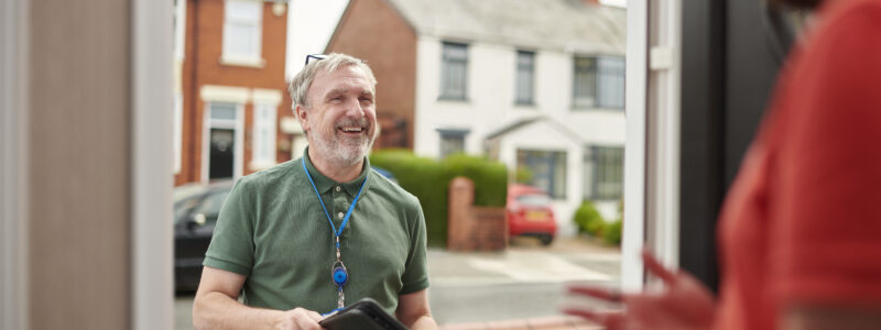 local housing officer calls on tenant holding a clipboard